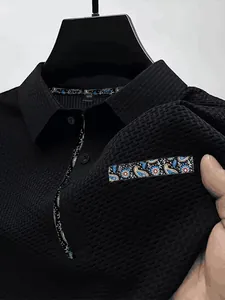Détail d'un t-shirt noir en soie glacée avec motifs cachemire au col