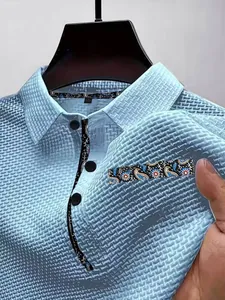 Vue détaillée d'un polo bleu clair en soie glacée avec une texture en maille filet