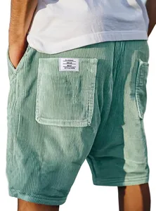 Detailopname van vintage mintgroene corduroy korte broek met een geborduurd zaklabel
