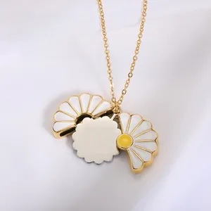 Detailed view of a golden daisy flower locket necklace with a DIY engravable plate