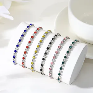 Detailed view of multiple colorful zircon tennis bracelets on white display stand