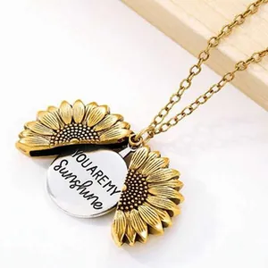 Detailed view of antique gold sunflower locket necklace with You Are My Sunshine engraving