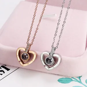 Close-up detail of two heart necklaces in rose gold and silver with projection stones.