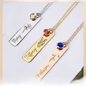 Detailed view of three custom engraved bar necklaces with birthstones and flowers