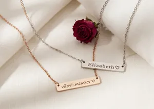 Close-up of personalized engraved bar necklaces in silver and rose gold finish