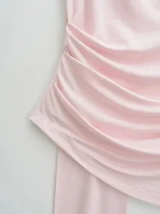 Detailed close-up view of pink ruched halter top fabric showing soft drapery texture