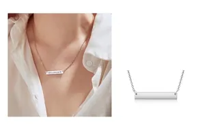 Close-up detail of personalized silver bar necklace with custom name engraving on a model