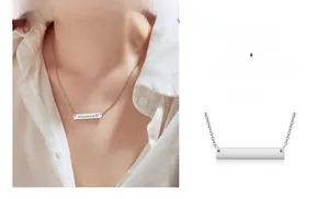 Close-up detail of personalized silver bar necklace with custom name engraving on a model