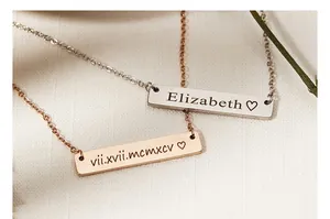 Close-up of two personalized rectangular bar necklaces with custom name and date engraving