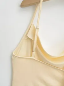 Detail of adjustable straps on a soft light yellow camisole tank top for women