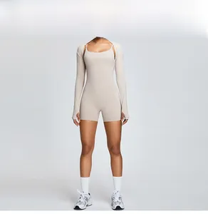 Full body view of model wearing beige fitness shrug and matching one-piece bodysuit set