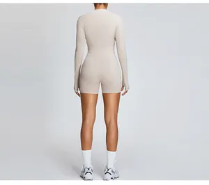 Back view of a woman in a beige long-sleeve athletic shrug and matching shorts