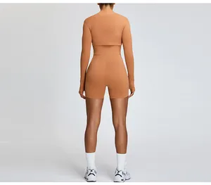 Back view of woman in ginger long sleeve cropped yoga shrug and biker shorts set