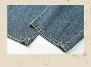 Detail shot of vintage washed blue denim pants hem featuring distressed edges