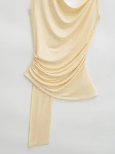 Detailed macro shot of yellow draped cowl neck camisole with side ruching texture