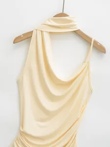 Detail shot of elegant pale yellow halter-neck draped top on a wooden hanger