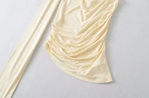 Close-up of yellow ruched halter vest showing soft fabric texture and pleated detail.