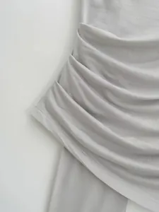 Macro view of light grey ruched fabric detail and stitching on a summer camisole