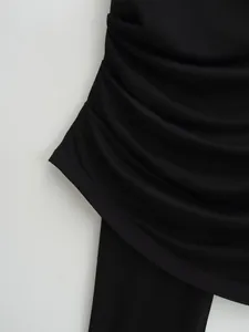 Detailed view of the elegant ruched fabric and stitching on a black camisole top
