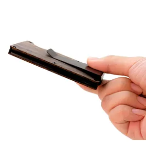 Side view of a slim wooden RFID blocking card holder with a black metal clip held in hand