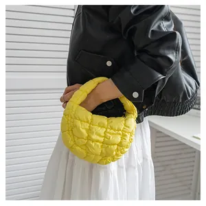 Primo piano di una borsa gialla trapuntata puffy cloud con morbida imbottitura