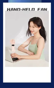 Portable mini handheld USB fan with digital display used by woman at a white office desk