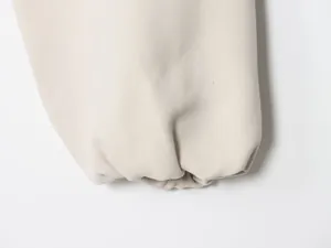 Detailed view of the elasticated cuff and woven texture on a beige puff jacket for women