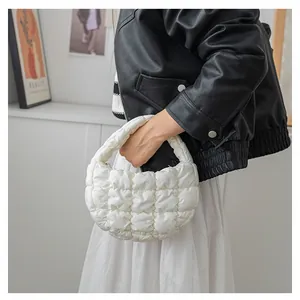 Vista dettagliata di una borsa a mano bianca a nuvola trapuntata con un modello.