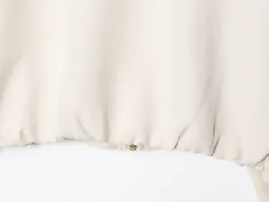 Close-up detail of the elastic hem and golden zipper on a beige fashion puffer jacket