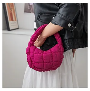 Dettaglio di una mini borsa a nuvola trapuntata magenta vivace tenuta da una modella