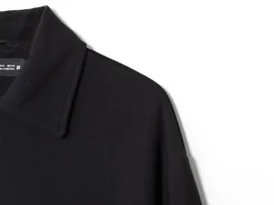 Close-up view showing the black jacket collar and professional shoulder stitching detail