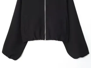 Close-up view of a black puff sleeve jacket featuring a sleek silver zipper closure