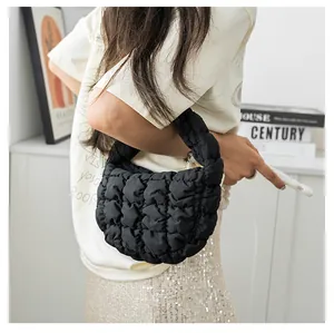 Modella che porta una borsa a nuvola nera trapuntata con una morbida trama soffice