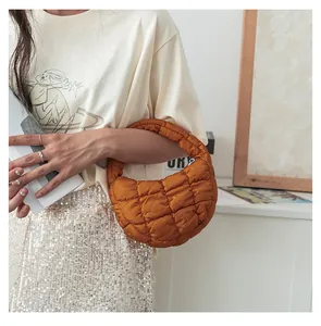 Vista dettagliata di una borsa a nuvola trapuntata marrone tenuta da una modella