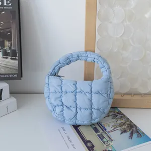 Vista detallada del bolso de mano acolchado azul claro con suave relleno de algodón
