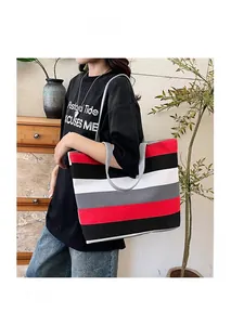 Modell mit einer großen gestreiften Canvas-Einkaufstasche in Innenräumen
