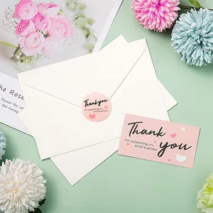 Detail view of pink thank you cards and stickers for small business gift packaging