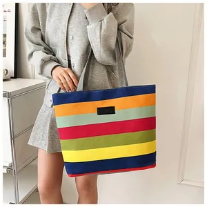 Detailed view of a large capacity canvas tote bag featuring vibrant rainbow horizontal stripes