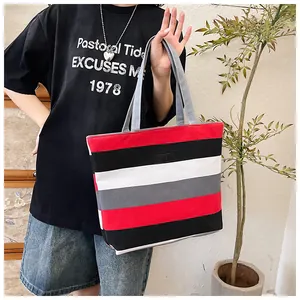 Model carrying a large capacity striped canvas tote bag in a casual setting