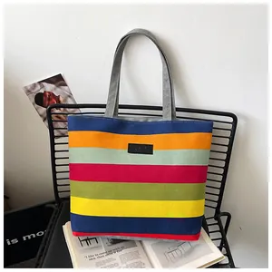 Detailed view of a colorful striped canvas tote bag placed on a modern chair
