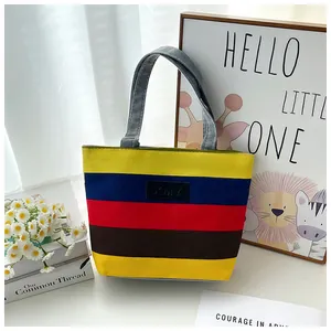 Colorful striped canvas tote bag displayed with floral and artistic props