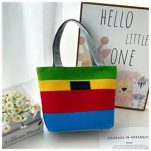 Detailed view of the vibrant rainbow striped canvas tote bag with KMY logo patch