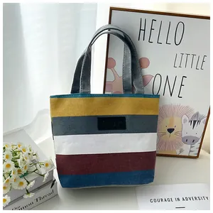 Large striped canvas tote bag shown in a cozy lifestyle setting with flower props