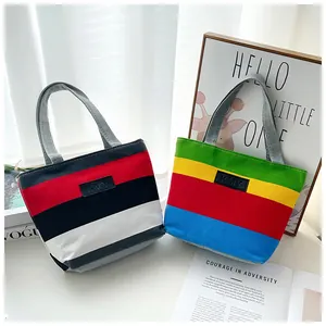 Close-up showing the vibrant striped patterns and KMY leather patch on canvas tote bags