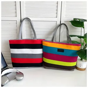 Close-up detail of two colorful striped canvas tote bags in a modern workspace setting