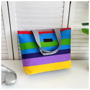 Detailed macro view of a large canvas tote bag featuring vibrant rainbow stripes