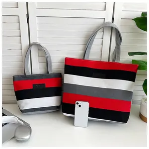 Two sizes of striped canvas tote bags in red, black, and white shown with a smartphone scale