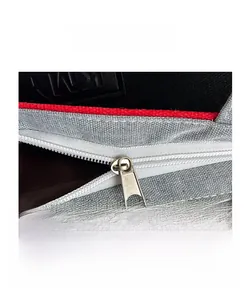 Nahaufnahme des hochwertigen Metallreißverschlusses einer grauen Canvas-Tasche.