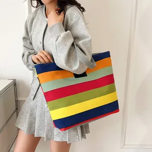 Grande borsa tote in tela con strisce orizzontali multicolore indossata da una modella