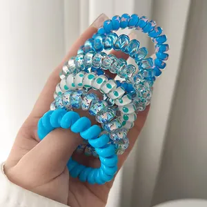 Detailed close-up showing various colorful spiral hair ties with star and floral patterns